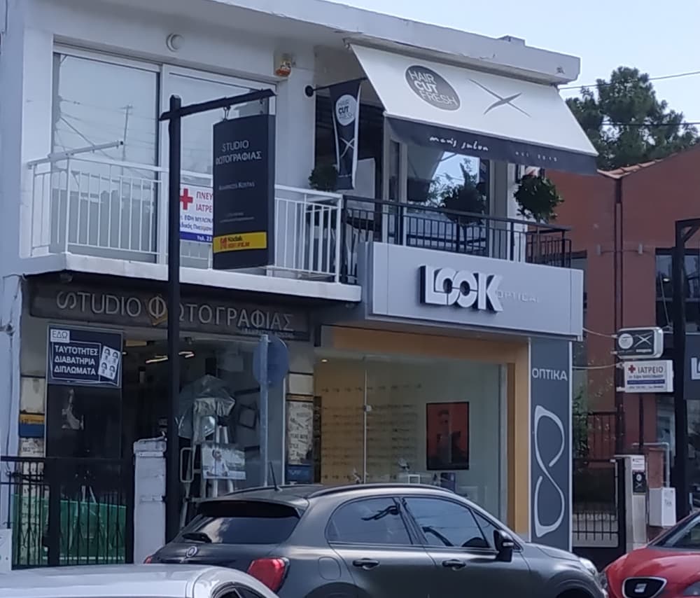 Το κτίριο στην Κομνηνών 7: το LOOK Optical στο ισόγειο και από πάνω, στον πρώτο όροφο, η τέντα του Haircut Fresh